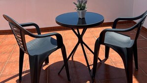 A terrace with two chairs and a table, overlooking the sea and a distant island. - Beachfront Villa with private pool (La Oliva)