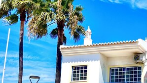 A two-story building with a sign reading 'Apartamentos Sereia da Oura' and 'Reception.'