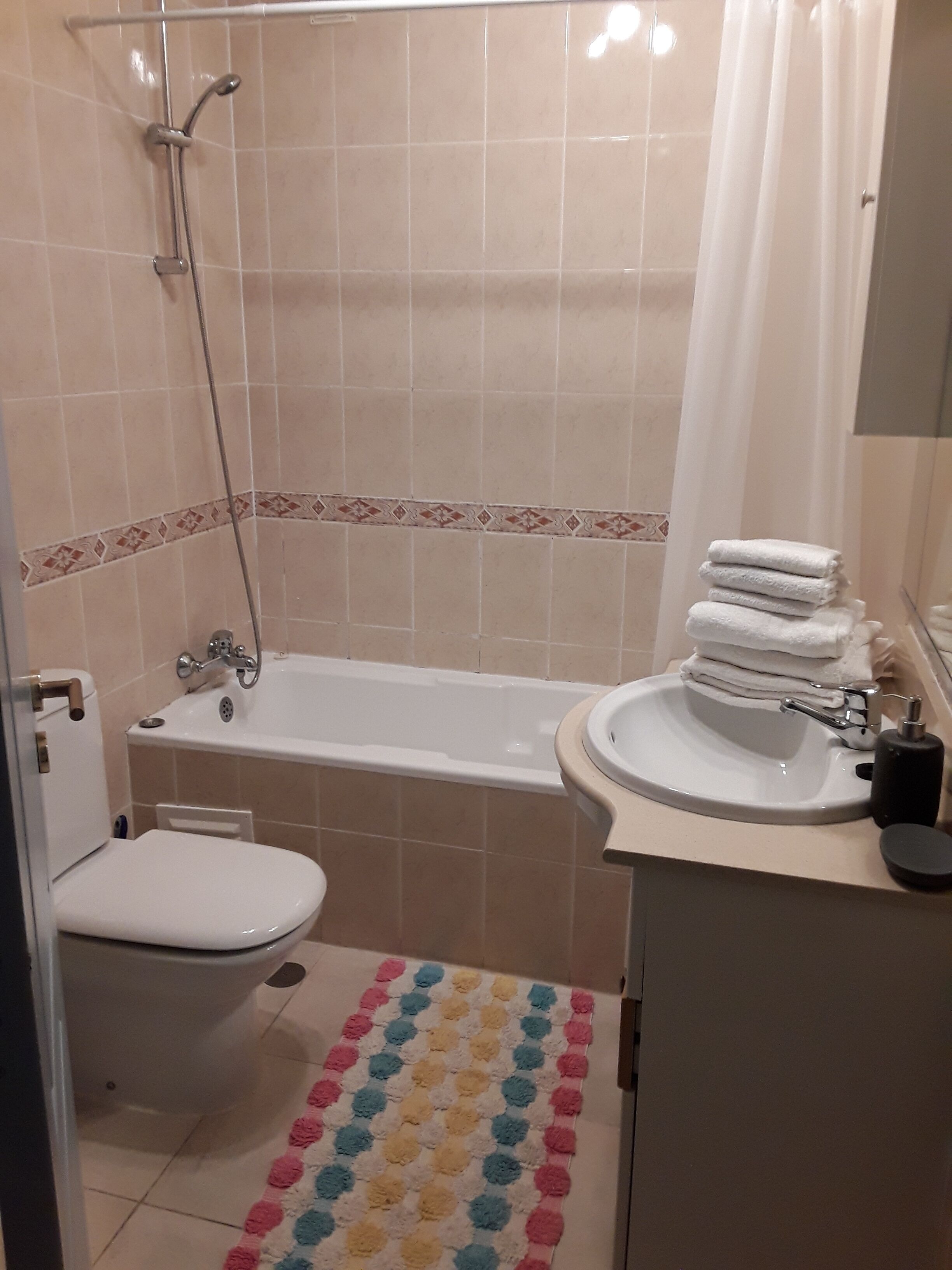 A bathroom with a toilet, sink, and bathtub.