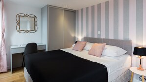 Une chambre d’hôtel moderne, équipée d’un lit, d’un bureau et d’une chaise.