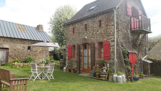A stone house with a balcony, a wooden table and chairs, and potted plants. - Intimate stone-built stable, suitable for couples in a rural setting (Bais)