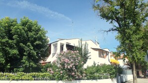 A building with a white facade, a visible entrance, and a balcony.