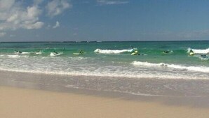 A beach with waves and a clear sky.