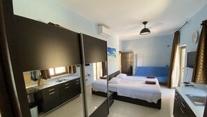 Una habitación de hotel con cama, escritorio, espejo, lavamanos y ventana.