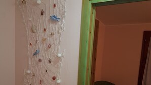 Una habitación con una cama, una silla y un adorno en la pared.