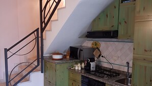 Una cocina con armarios verdes, una estufa y un fregadero.