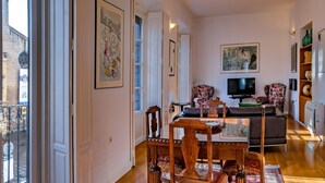 A spacious living room with a dining area, large windows, and a view of a historic building. - House with terrace in the center of Seville with wifi, air conditioning and garage (Sevilla)