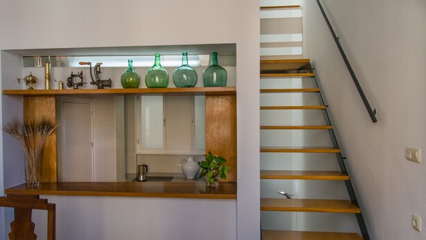 A kitchen with a wooden countertop, a sink, and a mirror above it. There are green bottles on the countertop and a plant on the counter. - House with terrace in the center of Seville with wifi, air conditioning and garage (Sevilla)