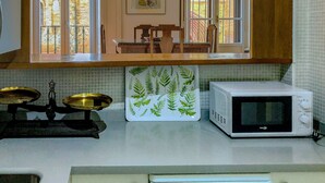 A kitchen with a microwave, a scale, and a decorative tile with fern patterns. - House with terrace in the center of Seville with wifi, air conditioning and garage (Sevilla)