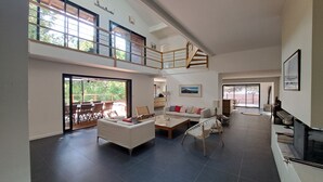 Un vaste espace de vie doté d’un haut plafond, d’un balcon et d’un escalier.
