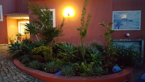 Ein angelegter Garten mit verschiedenen Pflanzen und einem Weg zum Gebäudeeingang.