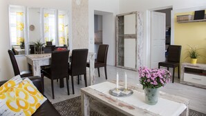 Un comedor con una mesa de madera, sillas y un florero.