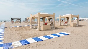 A beach with sun loungers and beach umbrellas.