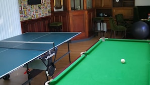 A room with two pool tables, a billiard ball, and a wall with comic book posters. - Recently refurbished barn, close to coast, pet friendly with a secure garden. (Lessingham)