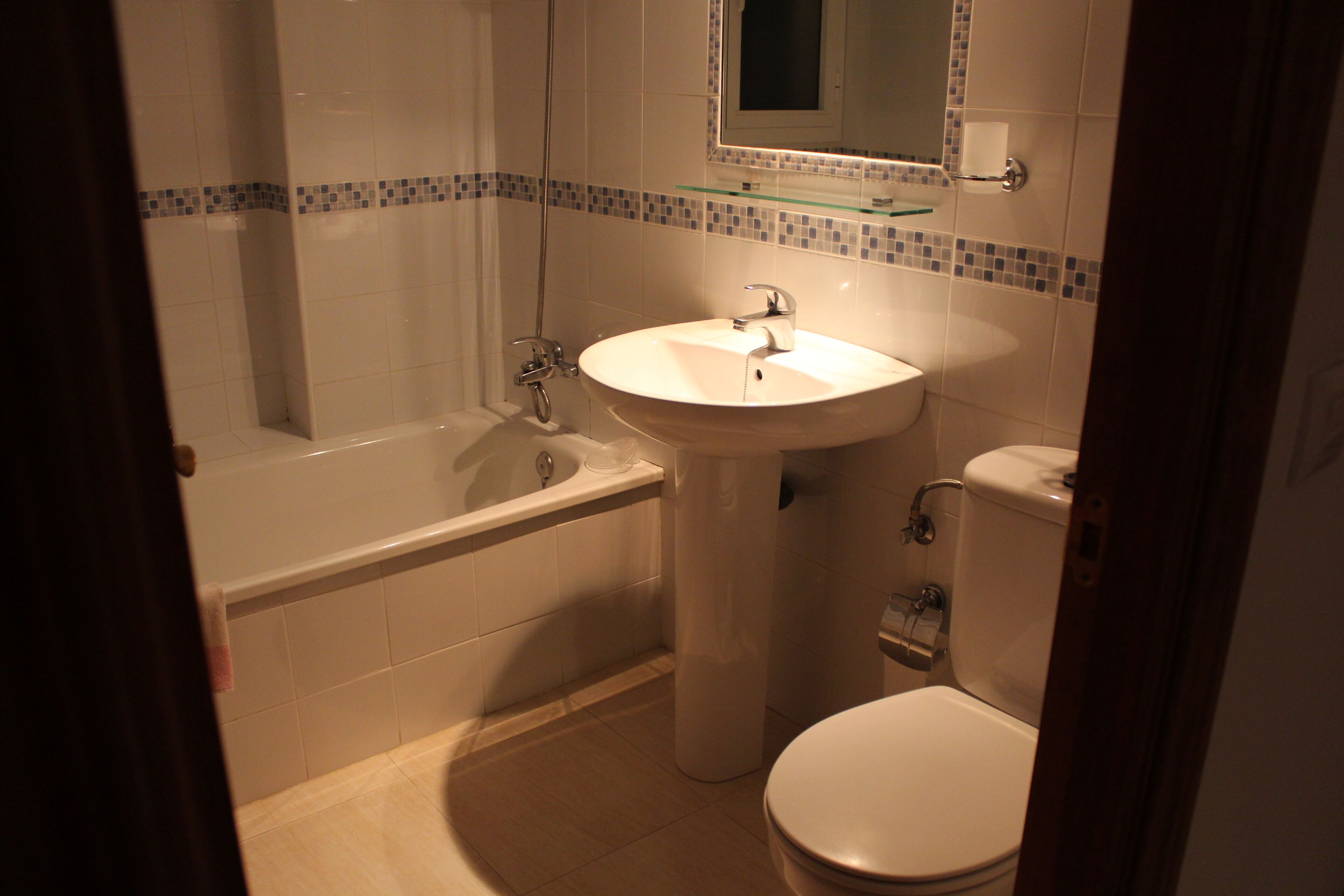 A bathroom with a bathtub, sink, and toilet.