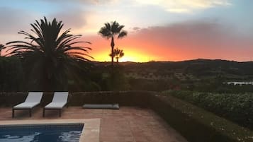 A heated pool, sun loungers