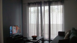 A living room with a television, a coffee table, and a sofa. - excellent for families (Portimão)