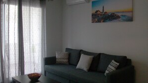 A living room with a grey sofa, a coffee table, and a painting of a coastal landscape. - excellent for families (Portimão)