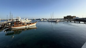 A marina with several boats docked, a bridge in the background, and a building on the right. -  2 Bedroom Apartment, Sirena Sunrise, Paphos (Paphos)