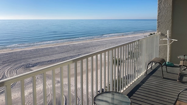 Een balkon met uitzicht op een strand en de oceaan.