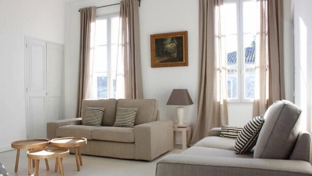 A modern living room with a beige sofa, two side tables, and a lamp. - Beautiful and quiet apartment in the heart of the Cité des Papes (Avignon)