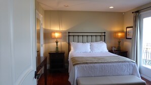 A neatly arranged bedroom with a bed, bedside tables, and a bench.