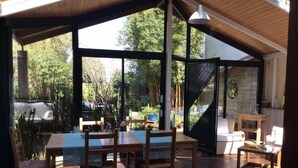 A covered patio with a dining table and chairs, a sofa, and a small table. - Mansion - Ploemeur (Ploemeur)