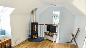 Een gezellige woonkamer met een open haard, een televisie en een bank.