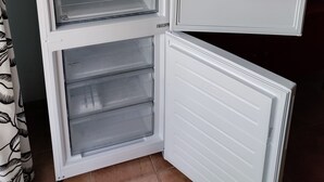 An open refrigerator with multiple shelves and compartments, including a freezer section at the bottom.