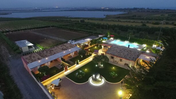 An aerial view of a resort with a swimming pool, a fountain, and a landscaped garden. - Villa Fenicottero - A Charming Oasis in Nature (Ispica)