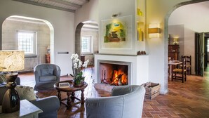 Un salon spacieux doté d’une cheminée, de sièges confortables et d’une grande fenêtre.