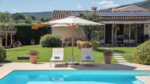 Un'area piscina con lettini e un gazebo.