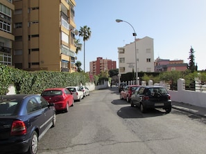 A street with parked cars, a building with balconies, and a clear sky. - Studio Apartment, Sleeps 2. Centrally located & close to all amenities. (Benalmádena)