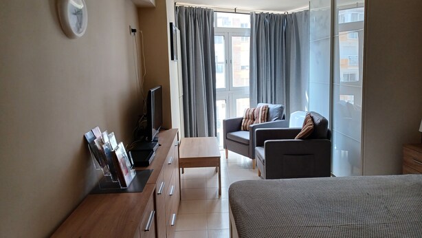 A modern living room with a sofa, a TV, and a desk with drawers. - Studio Apartment, Sleeps 2. Centrally located & close to all amenities. (Benalmádena)