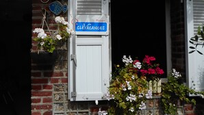 Une entrée d’immeuble avec une enseigne indiquant « CléVacances » et une fenêtre dotée de volets blancs.