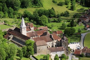 An aerial view of a historic town with a prominent church, narrow streets, and surrounding greenery. - Chalet - DOUCIER LAC DE CHALAIN (Doucier)