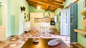 A kitchen with white cabinets, a dining table with two bowls, and a wooden ceiling.