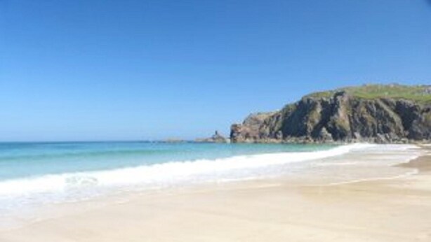 A beach with clear blue water and a rocky cliff. - Detached spacious Isle of Lewis cottage in tranquil position with loch view (Carloway)