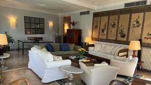 A spacious living room with a sofa set, a coffee table, and a dining area with a table and chairs.