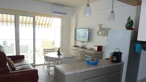 A compact kitchen with a dining area, a TV, and a refrigerator. - Magnificent apartment T3 sea view 180 degrees, Sea at 20 meters (Le Lavandou)