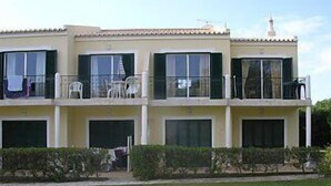 A two-story building with balconies, a swimming pool, and a well-maintained lawn. - Lovely Apartment, Ponta da Piedade Natural Reserve, Camilo Beach, Dona Ana Beach (Lagos)