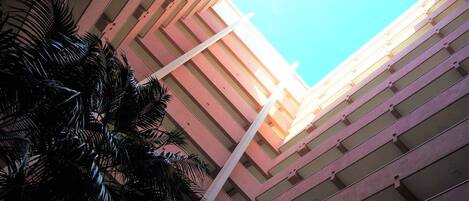 A high-rise building with a clear sky view, featuring a modern architectural design with horizontal lines and a central white column.