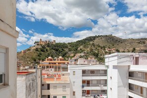 A view of a hillside with a castle-like structure, residential buildings, and a clear sky. - Apartment/ flat - Cullera (Cullera)