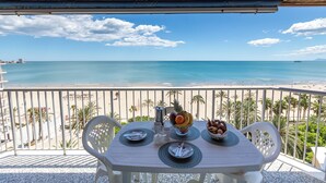 A balcony with a table set for breakfast, overlooking a beach with clear blue water and a few boats. - Apartment/ flat - Cullera (Cullera)