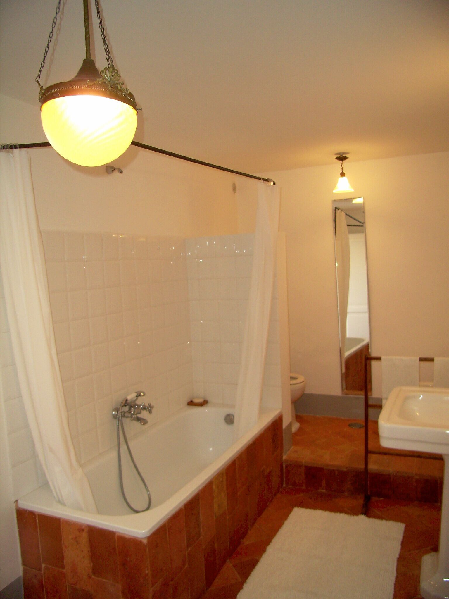 A bathroom with a bathtub, a sink, and a mirror.