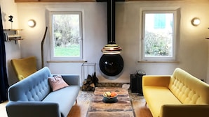 Una sala de estar acogedora con dos sofás, una mesa de centro de madera y una lámpara colgante.