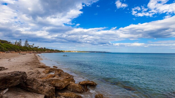 A beach with clear blue water, rocky shoreline, and a distant view of the coastline. - Villa With Pool Near The Sea.Syracuse, Plemmirio, Arenella,Fontane Bianche  (Siracusa)