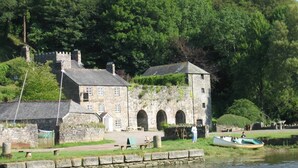 A stone building with a tower, a small dock, and a river. - Tin mine riverside retreat, log fires, views, wildlife, ruins, pet-friendly (Calstock)