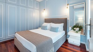 A bedroom with a bed, bedside table, and a mirror. - Victoria Project - Apartment II - Private Parking (Porto)
