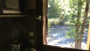 Una cucina con vista su un fiume attraverso una finestra.